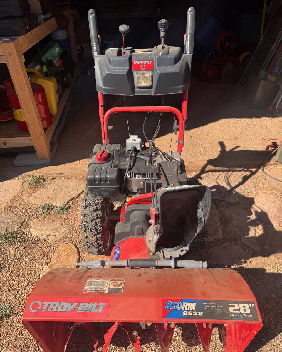 Red Troy-Bilt Storm 9528 two-stage snowblower outside the shop